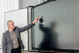 Schulungsleiter bedient interaktives Display mit Multitouch-Gesten